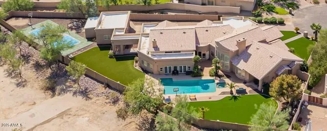 an aerial view of a house with a garden and lake view