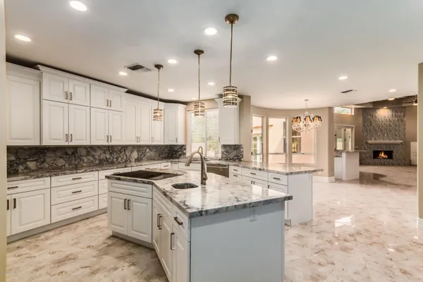 a kitchen with stainless steel appliances granite countertop a sink a stove and a refrigerator