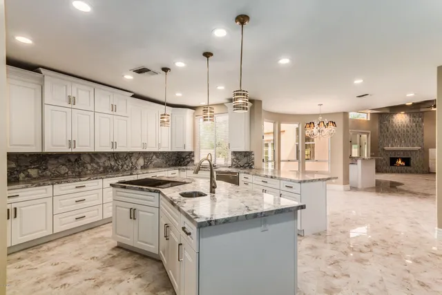 a kitchen with stainless steel appliances granite countertop a sink a stove and a refrigerator