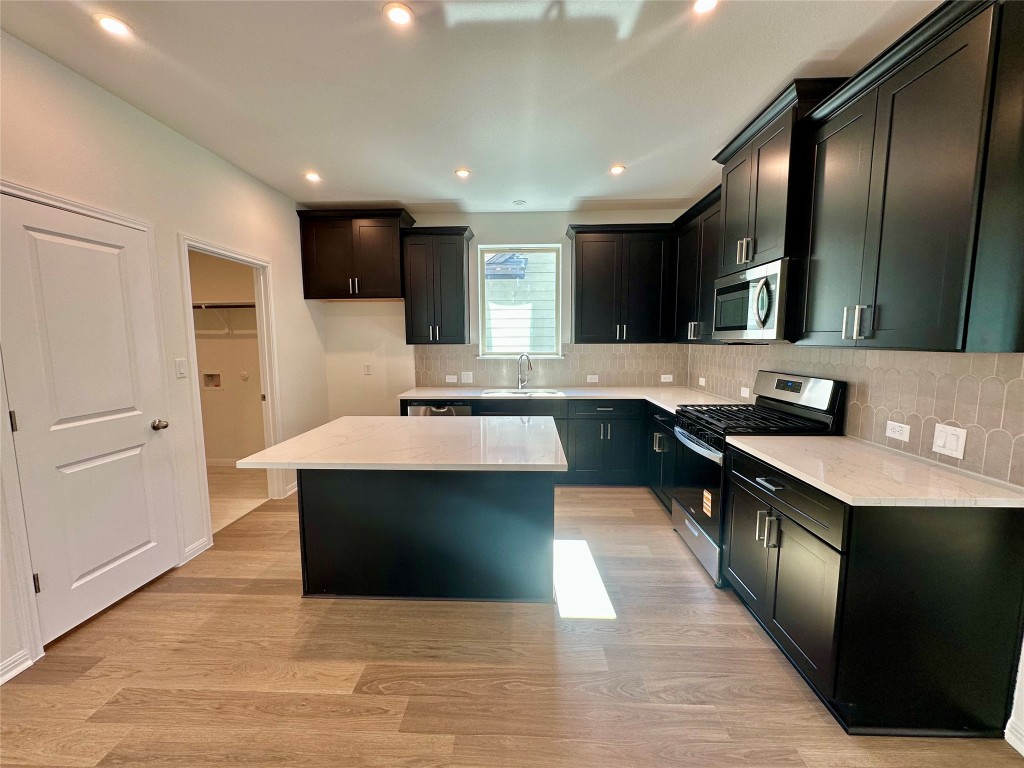 372 Glocken Lane Kyle, TX 78640 - Photo 9 of 37 a kitchen with stainless steel appliances granite countertop a sink and a stove
