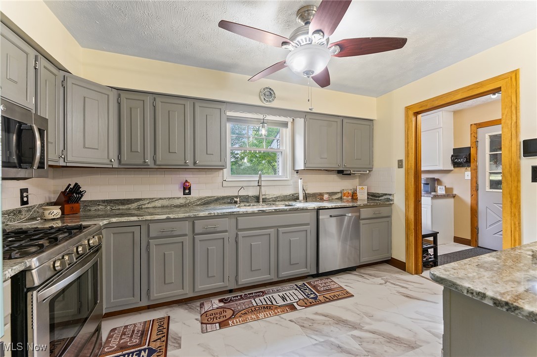6152 Chestnut-Ridge Road Hubbard, OH 44425 - Photo 8 of 28 Kitchen with ceiling fan, sink, backsplash, gray cabinets, and appliances with stainless steel finishes