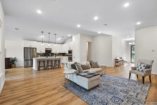 a living room with lots of furniture and kitchen view