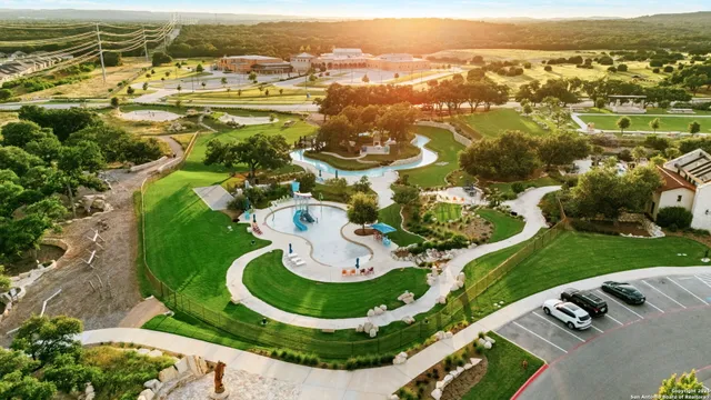 an aerial view of residential houses with outdoor space and trees