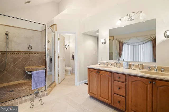 a bathroom with a double vanity sink a large mirror and shower