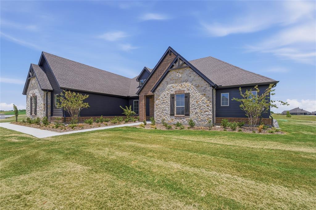 2305 Gypsum Street Krum, TX 76249 - Photo 3 of 26 Contemporary exterior featuring dark siding, stone accents, gabled rooflines, and a concrete pathway