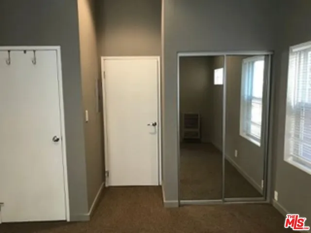 a large bed sitting in a bedroom next to a window