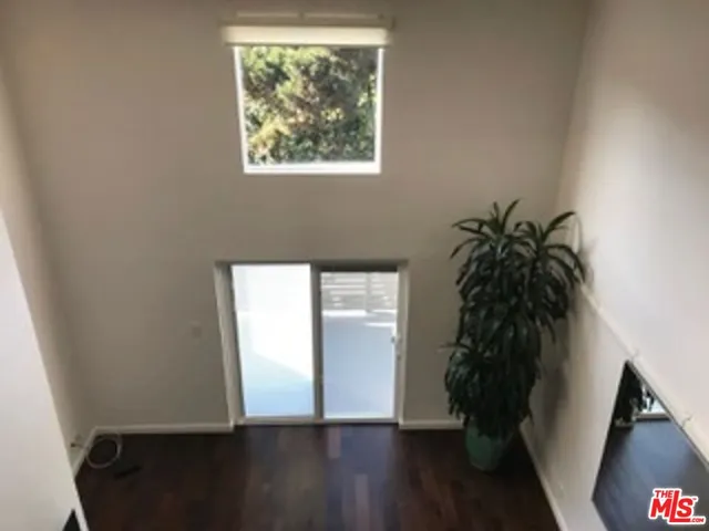 a large bed sitting in a bedroom next to a lamp with a dresser and a lamp