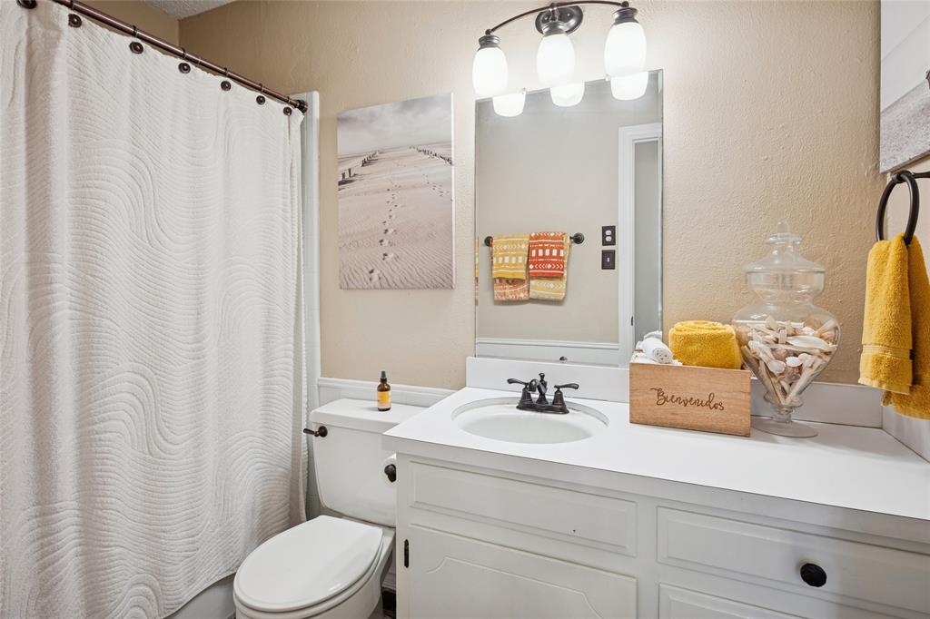 3701 Streamwood Road Fort Worth, TX 76116 - Photo 18 of 34 a bathroom with a sink a toilet and shower curtain