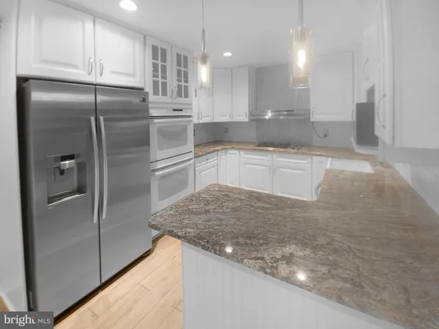 a kitchen with stainless steel appliances granite countertop a refrigerator and a sink