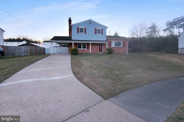 a view of a big house with a big yard and large tree