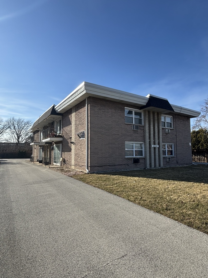 12702 Central Avenue, Unit 1B Crestwood, IL 60418 - Photo 1 of 11 a front view of a house with a yard and garage