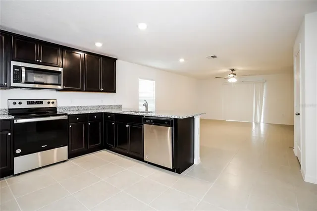 a kitchen with stainless steel appliances kitchen island granite countertop a stove a sink and a microwave