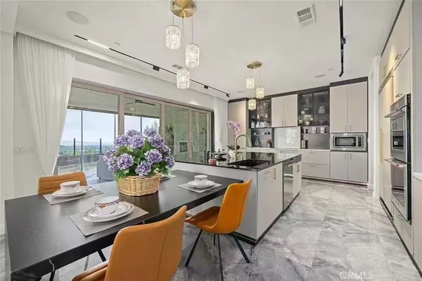 a kitchen with a dining table chairs stainless steel appliances and cabinets