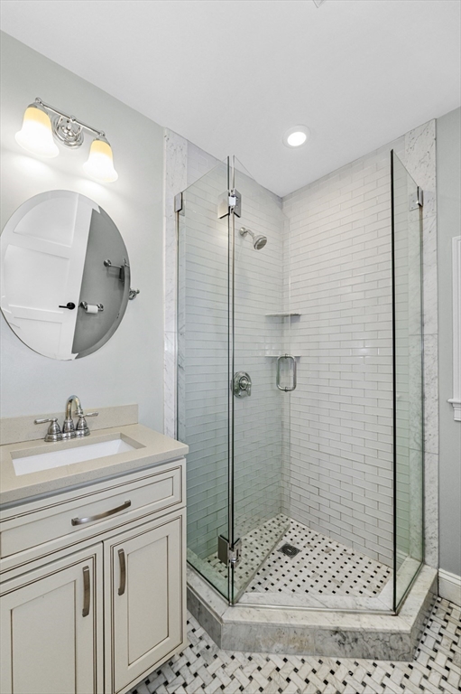 1880 Beacon Street, Unit 6 Brookline, MA 02445 - Photo 12 of 18 a bathroom with a sink a toilet a glass door a shower and a mirror