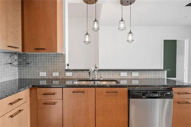 a kitchen with stainless steel appliances granite countertop a sink a stove and a refrigerator