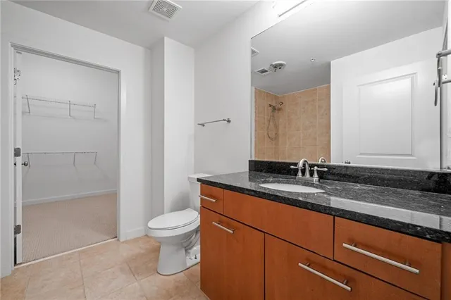 a bathroom with a granite countertop sink a toilet and a shower