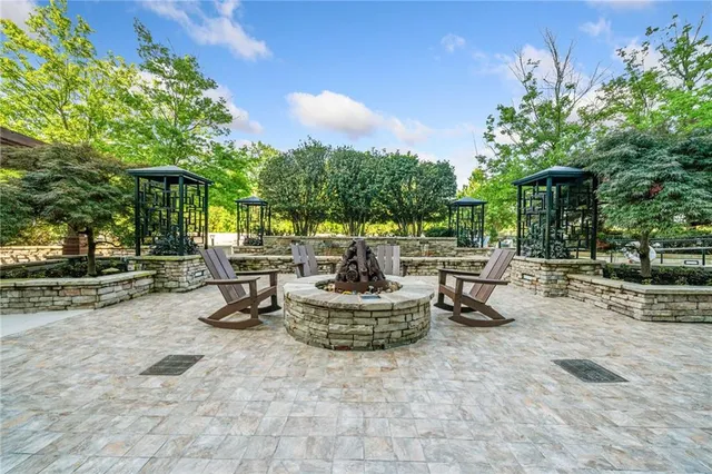 a view of a patio with table and chairs potted plants and large tree