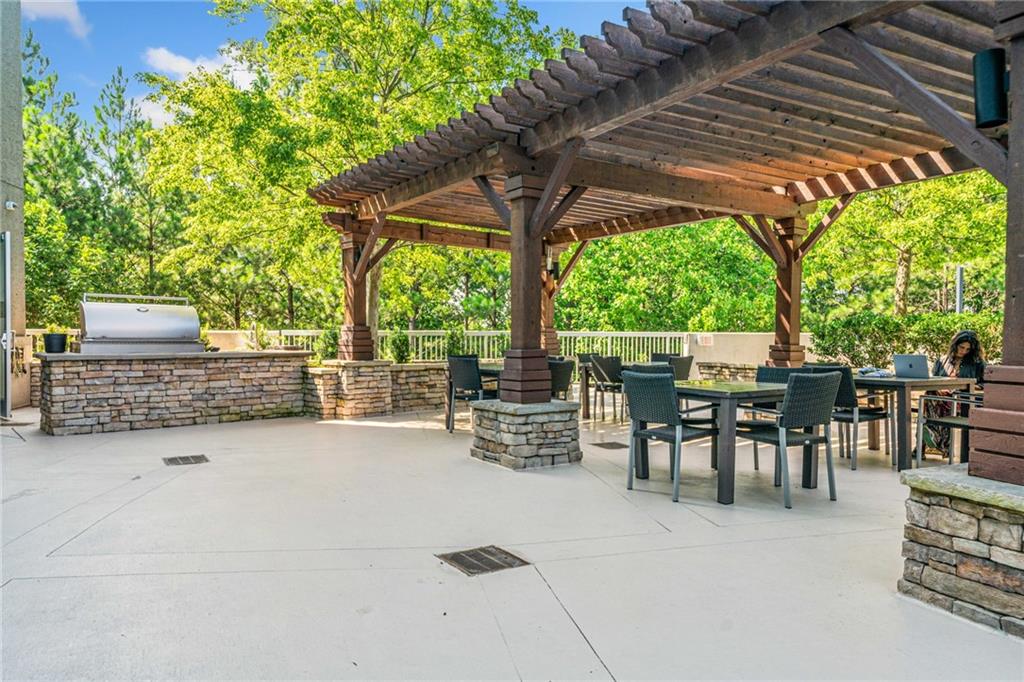 3300 Windy Ridge Parkway Southeast, Unit 1113 Atlanta, GA 30339 - Photo 25 of 39 a view of a patio with table and chairs potted plants and large tree