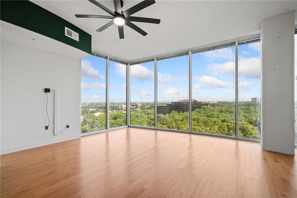 3300 Windy Ridge Parkway Southeast, Unit 1113 Atlanta, GA 30339 - Photo 7 of 39 a view of an empty room with wooden floor and windows