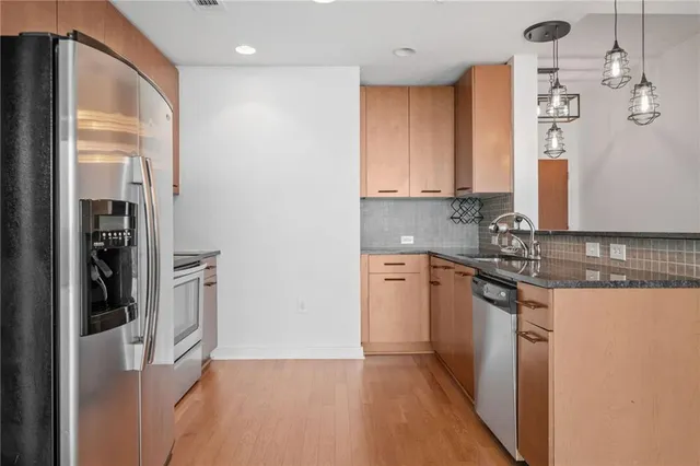 a kitchen with stainless steel appliances granite countertop a refrigerator and a sink