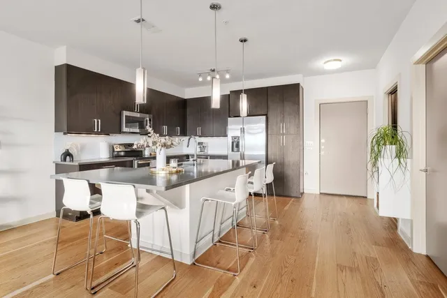 a kitchen with stainless steel appliances a sink a stove a microwave a sink a refrigerator and cabinets