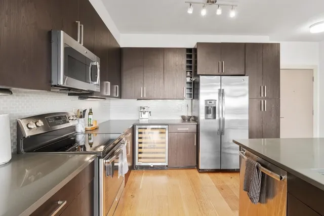 a kitchen with granite countertop a sink appliances and cabinets