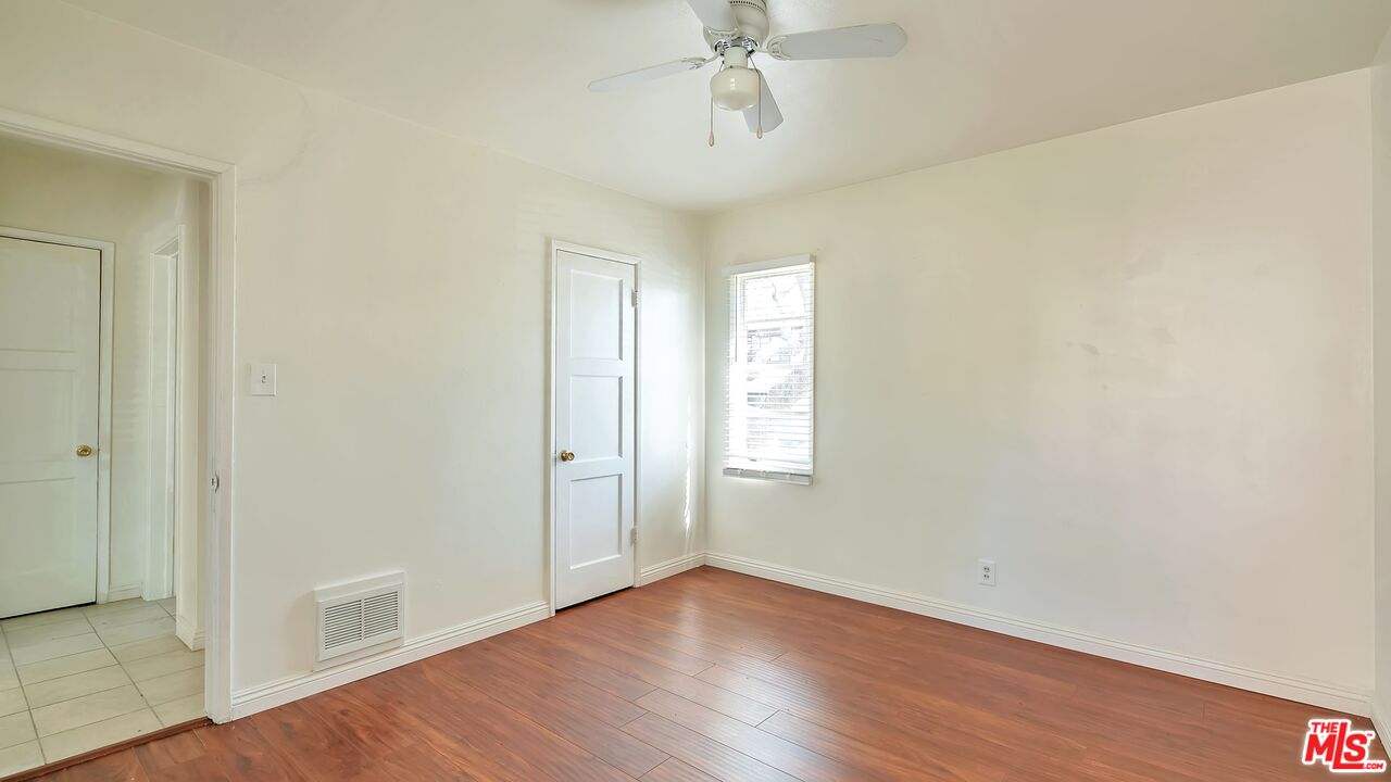 4063 Abourne Road, Unit B Los Angeles, CA 90008 - Photo 4 of 9 an empty room with wooden floor and windows