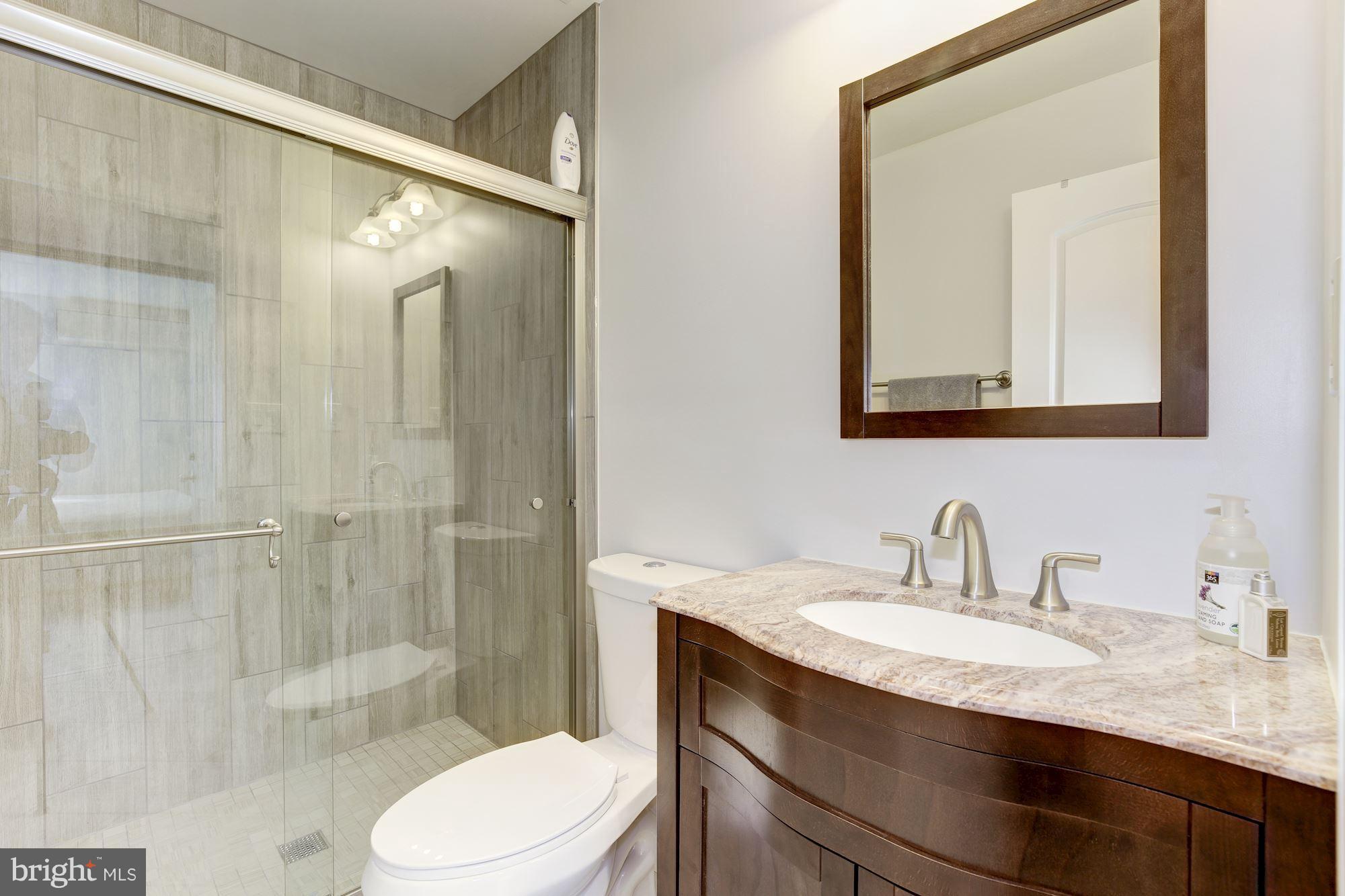 4949 Allan Road Bethesda, MD 20816 - Photo 15 of 27 a bathroom with a granite countertop sink toilet and shower