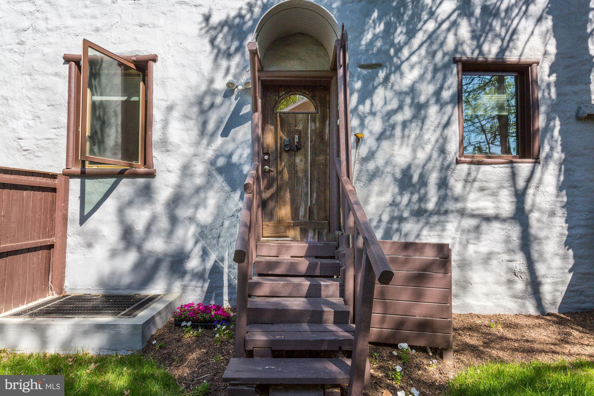 4949 Allan Road Bethesda, MD 20816 - Photo 20 of 27 a view of a brick house with a potted plant and a bench