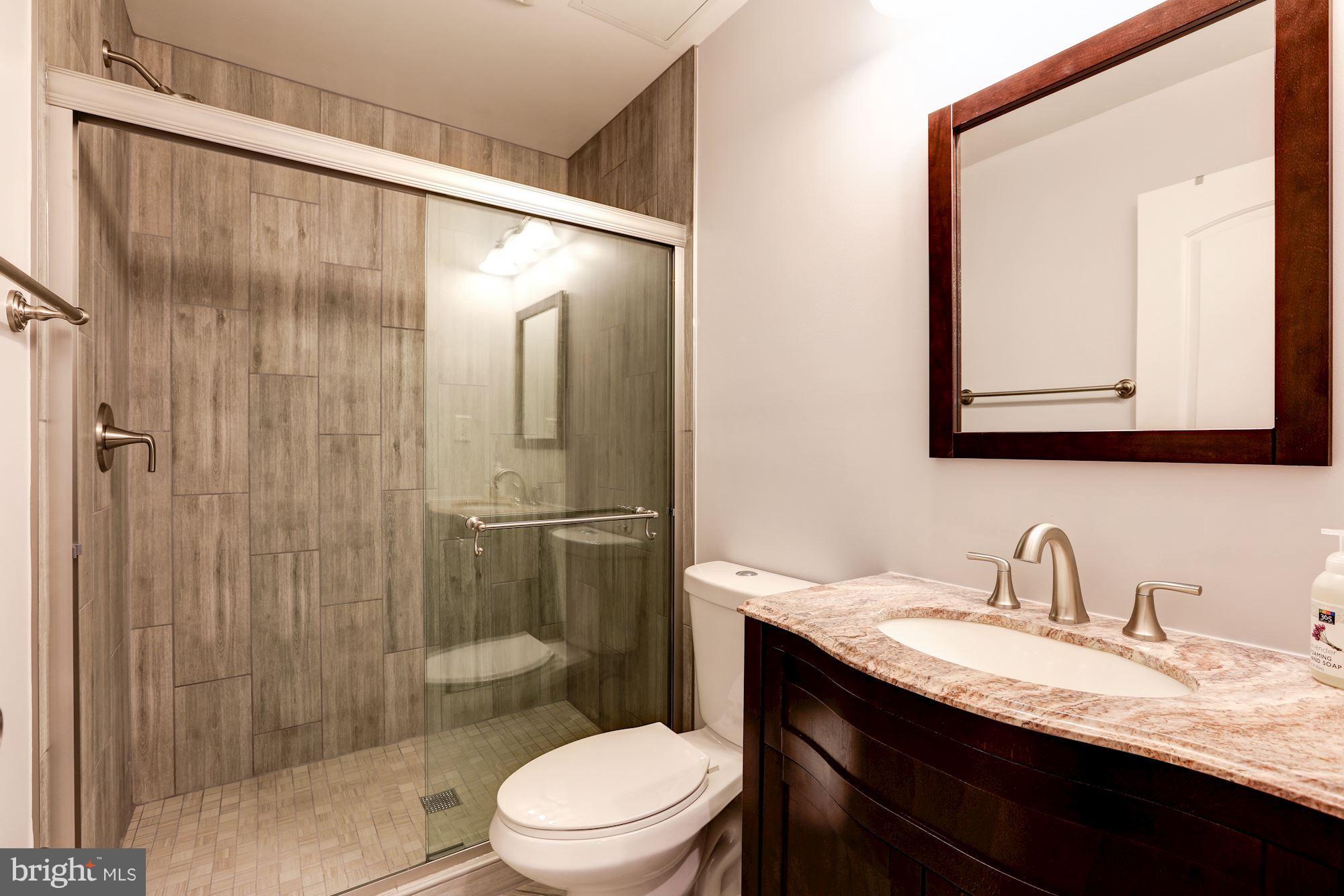 4949 Allan Road Bethesda, MD 20816 - Photo 27 of 27 a bathroom with a granite countertop sink toilet and shower