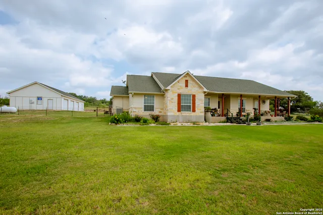 a view of a big house with a big yard and large trees