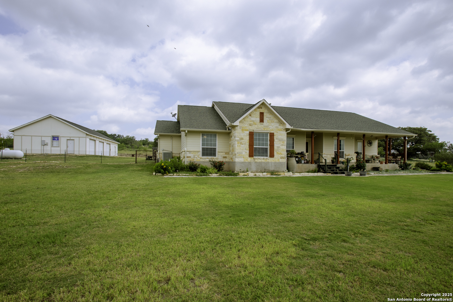 a view of a big house with a big yard and large trees