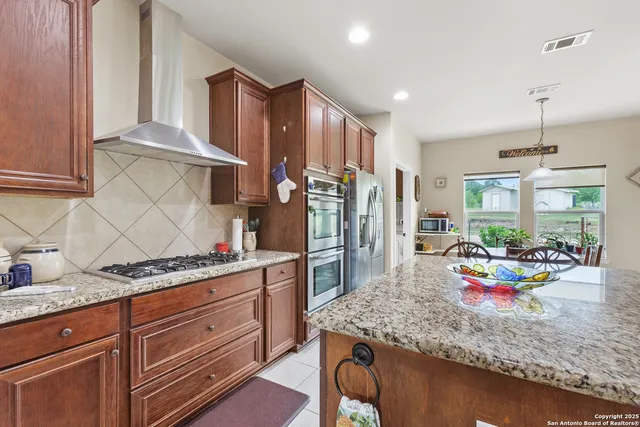 a kitchen with granite countertop lots of clutter and stainless steel appliances