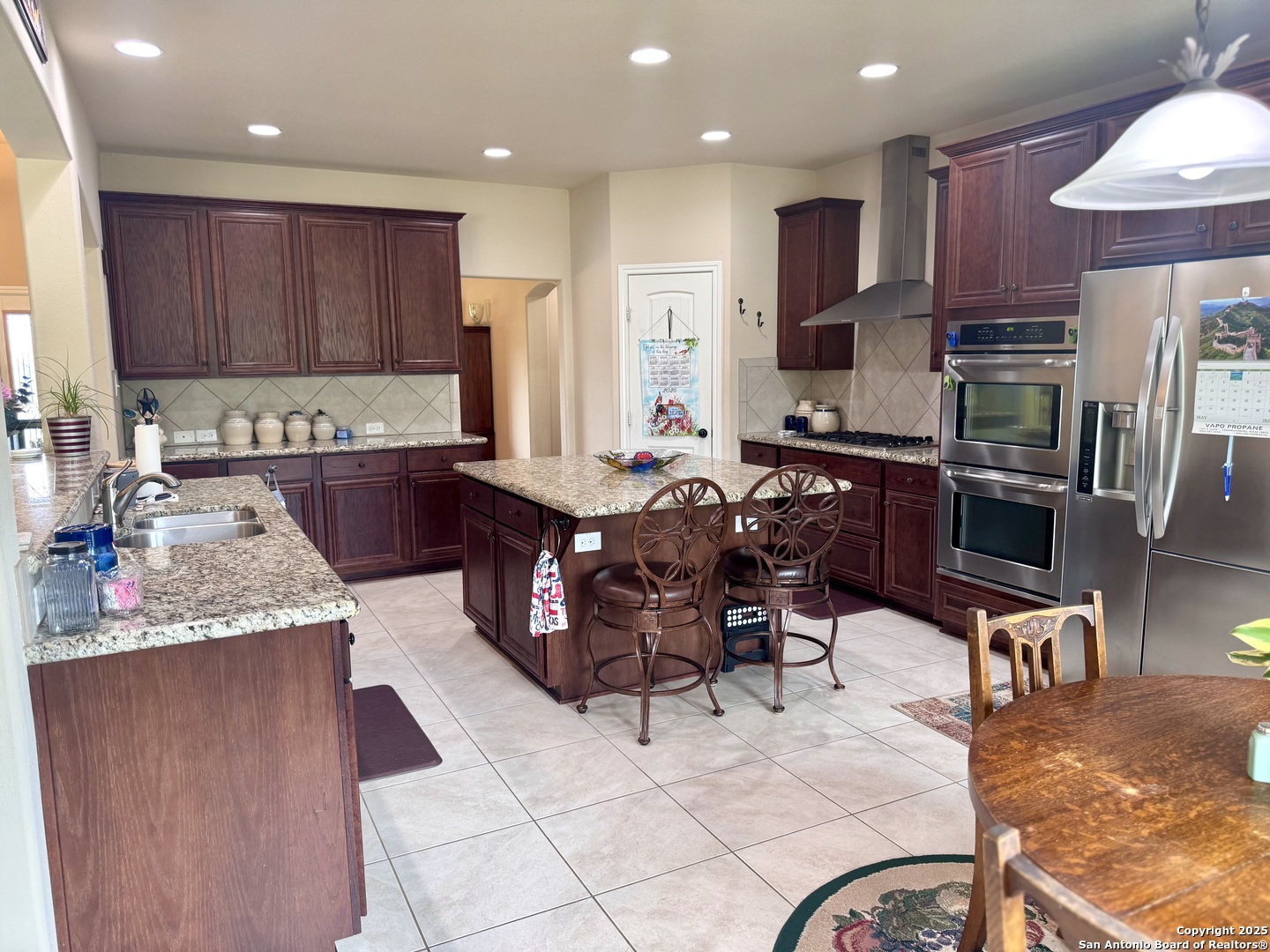 187 Tracks Center Point, TX 78010 - Photo 17 of 42 a kitchen with stainless steel appliances kitchen island granite countertop a table chairs sink and cabinets