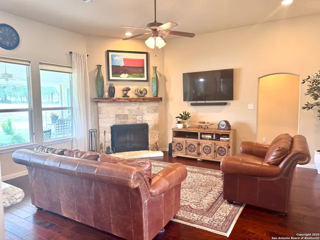 a living room with furniture a flat screen tv and a fireplace