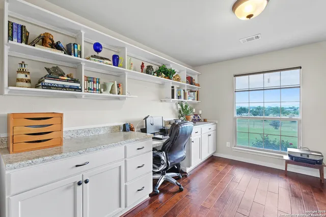 a view of workspace with wooden floor and a window