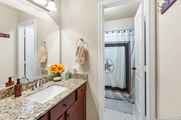 a bathroom with a granite countertop sink and a mirror