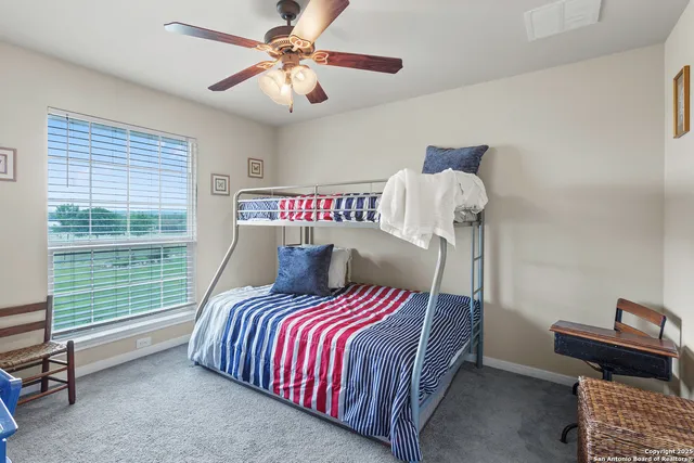 a bedroom with a bed and a chandelier fan