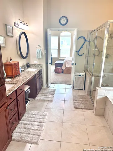 a large bathroom with a tub sink and mirror