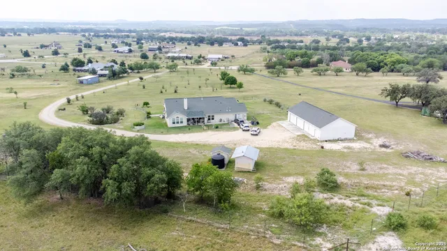an aerial view of residential houses with outdoor space and swimming pool