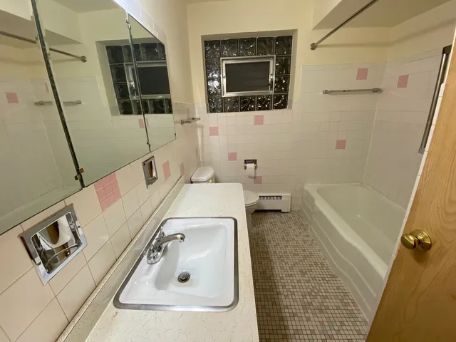 a bathroom with a sink a toilet and shower