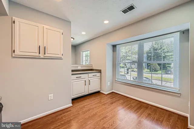 a view of a kitchen with an empty room and window