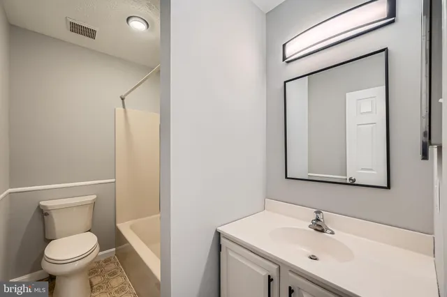 a bathroom with a sink toilet and a mirror