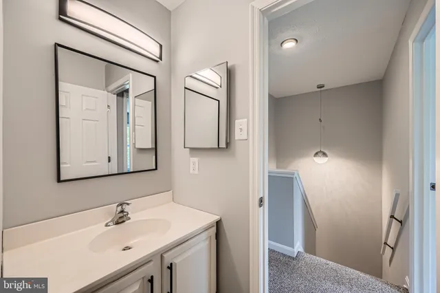 a bathroom with a sink vanity and mirror