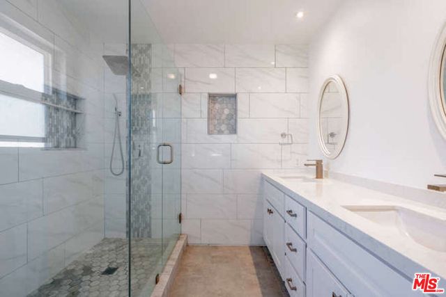 a spacious bathroom with a sink shower and a mirror