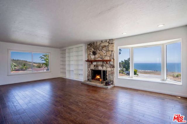 an empty room with fireplace and wooden floor