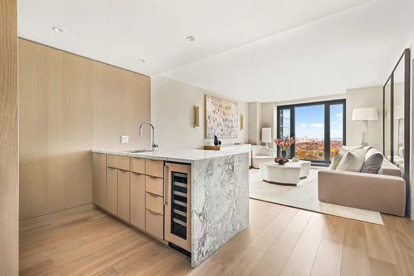 a living room with stainless steel appliances kitchen island granite countertop a sink cabinets and wooden floor