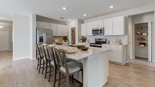 a kitchen that has a lot of cabinets a sink and appliances in it