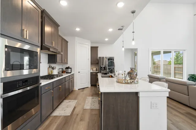 a kitchen with stainless steel appliances kitchen island granite countertop a sink and cabinets