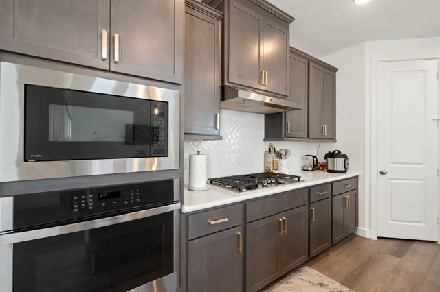 a kitchen with stainless steel appliances a stove a microwave and cabinets